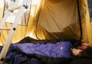Couple sleeping in a rooftop tent with sleeping bags on a Kimberley 4WD camping tour.