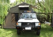 Toyota 4WD with rooftop tent and awning setup parked at a grassy Kimberley campsite.
