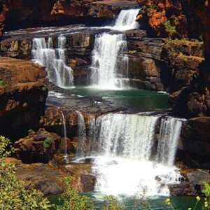 Scenic view of Mitchell Falls cascading over multiple rock tiers into emerald pools in the remote Kimberley region of Western Australia.